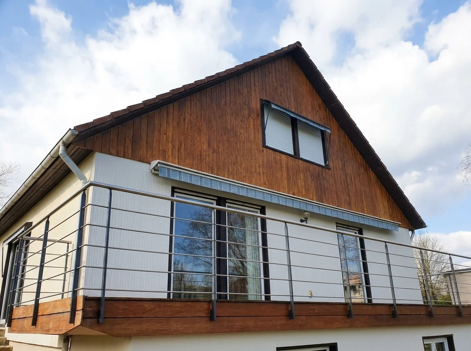 Extérieur d'un bâtiment moderne sous ciel nuageux avec végétation en arrière-plan